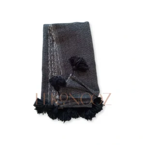 Patterned throw with pompoms